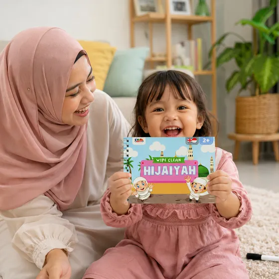 Ibu berhijab tertawa bersama putrinya yang memegang Wipe Clean Book Hijaiyah